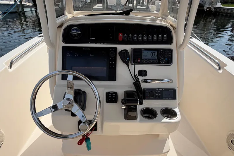 Slide: The Image of 2018 Grady-White Fisherman 236 boat dashboard with steering wheel and navigation controls. - 19