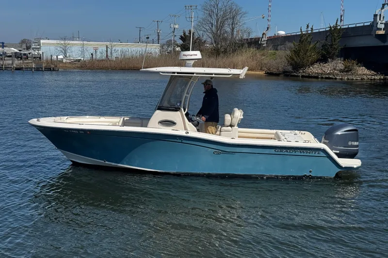 Slide: The Image of 2018 Grady-White Fisherman 236 boat on calm water, featuring a Yamaha engine. - 2