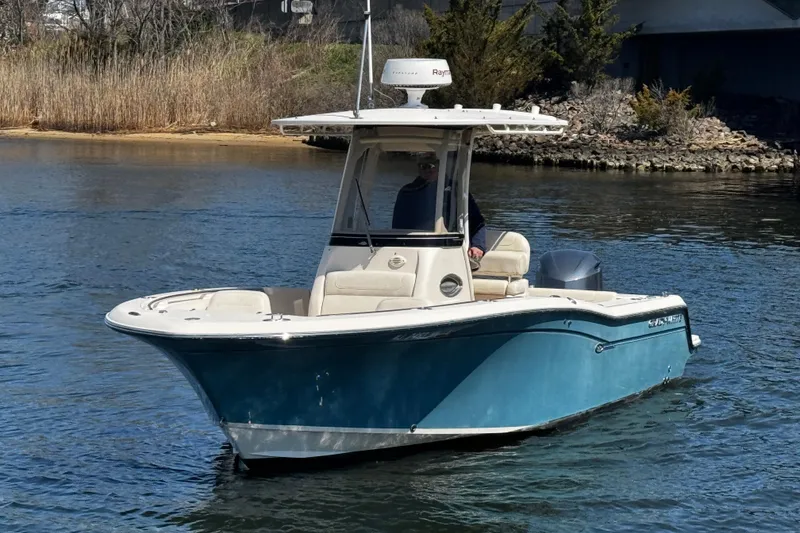 Slide: The Image of 2018 Grady-White Fisherman 236 boat on calm water, featuring a sleek blue hull. - 4