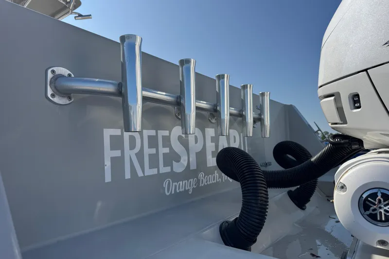 Slide: The Image of 2016 Contender 35 ST boat with rod holders and engine, labeled "Freespirit" in Orange Beach. - 14