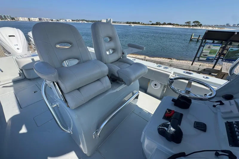 Slide: The Image of 2016 Contender 35 ST boat cockpit with dual seats and steering wheel, overlooking waterfront. - 4