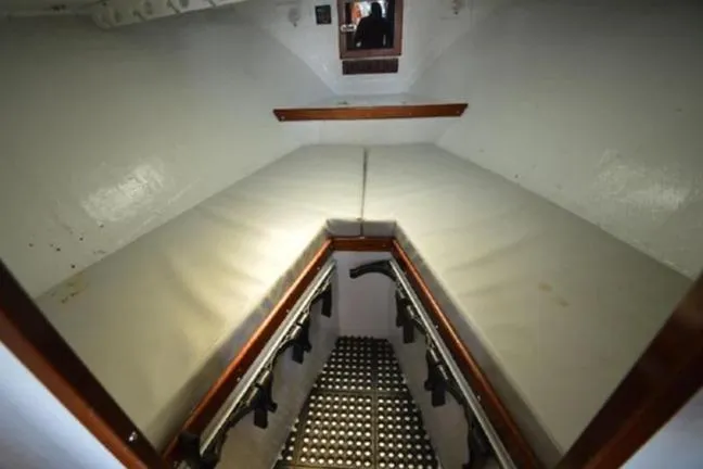 Slide: The Image of Interior cabin of 1996 KenCraft Down East Express 35 boat, featuring cushioned seating and storage. - 12