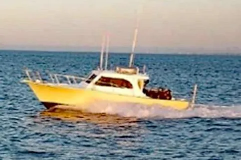 Slide: The Image of 1996 KenCraft Down East Express 35 cruising on open water at sunset. - 22