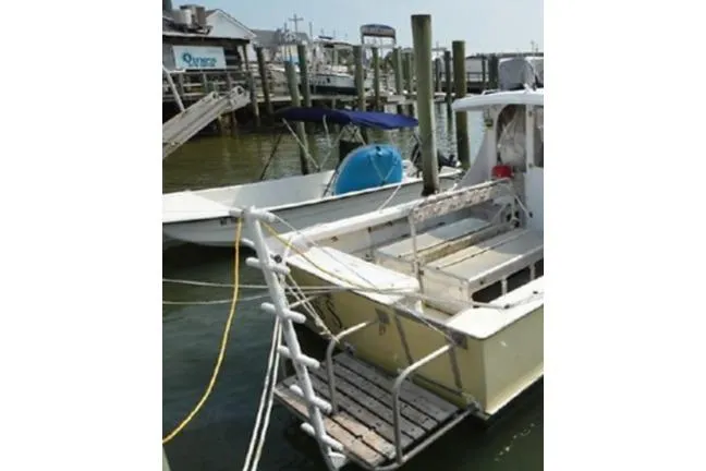 Slide: The Image of 1996 KenCraft Down East Express 35 docked at a marina with visible ladder and deck. - 25