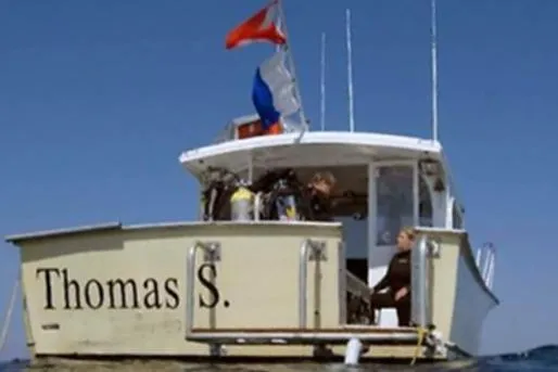 Slide: The Image of KenCraft Down East Express 35 boat, 1996 model, named "Thomas S." with flags, on water. - 26