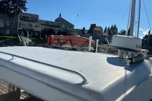 Slide: The Image of 1996 KenCraft Down East Express 35 boat docked near waterfront homes, featuring rooftop equipment. - 29