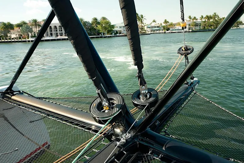 Slide: The Image of 2026 HH Catamarans HH60 sailing rigging detail on water with coastal backdrop. - 14