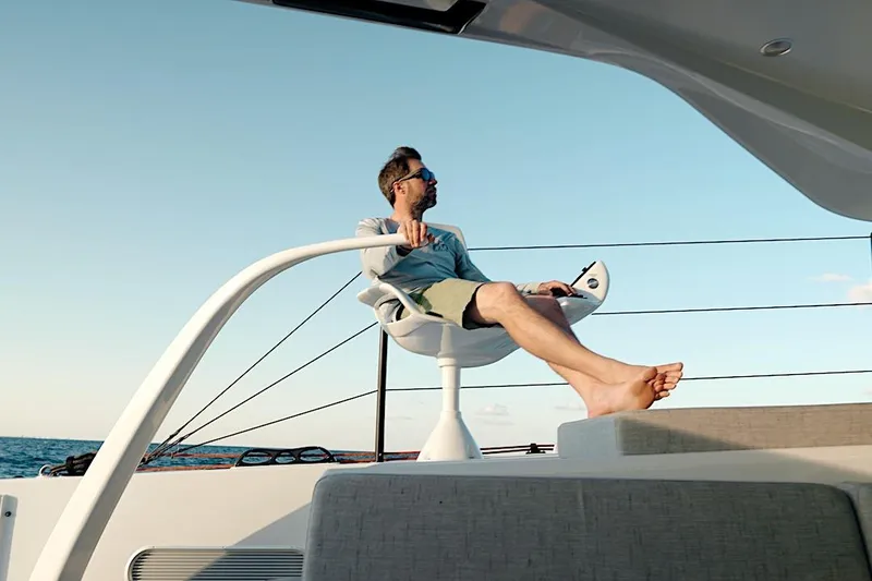 Slide: The Image of Man relaxing on a 2026 HH Catamarans HH60, enjoying the ocean view. - 18