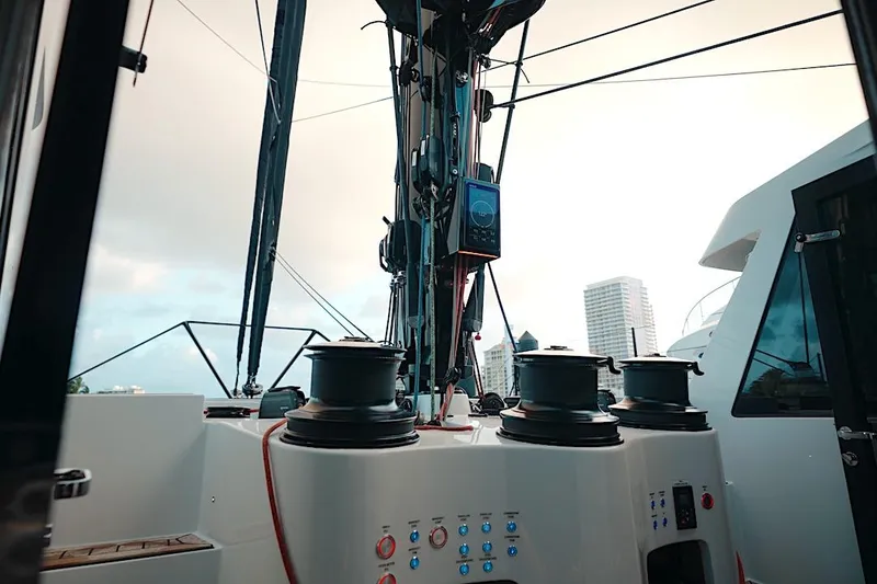 Slide: The Image of 2026 HH Catamarans HH60 yacht deck with winches and control panel, city skyline in background. - 26