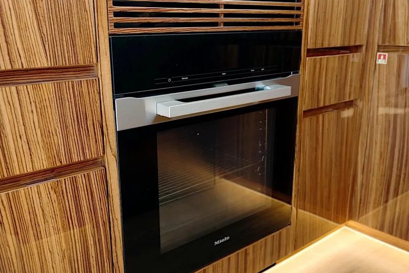 Slide: The Image of Built-in oven in luxurious wood-paneled kitchen of 2026 HH Catamarans HH60. - 35