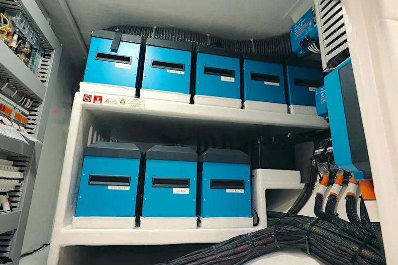 Slide: The Image of Electrical system of 2026 HH Catamarans HH60, featuring blue battery units and wiring. - 54