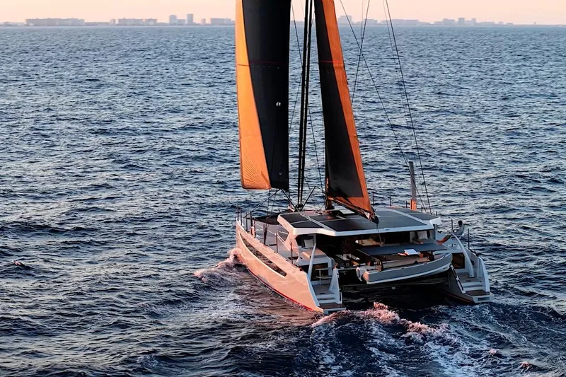 Slide: The Image of 2026 HH Catamarans HH60 sailing on open sea at sunset. - 6
