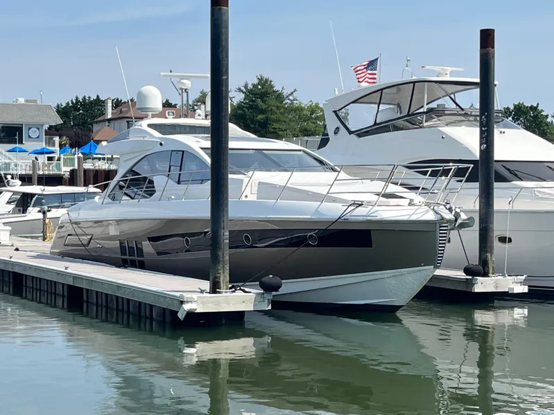Slide: The Image of 2014 Azimut 55S yacht docked at marina, clear sky, American flag visible. - 5