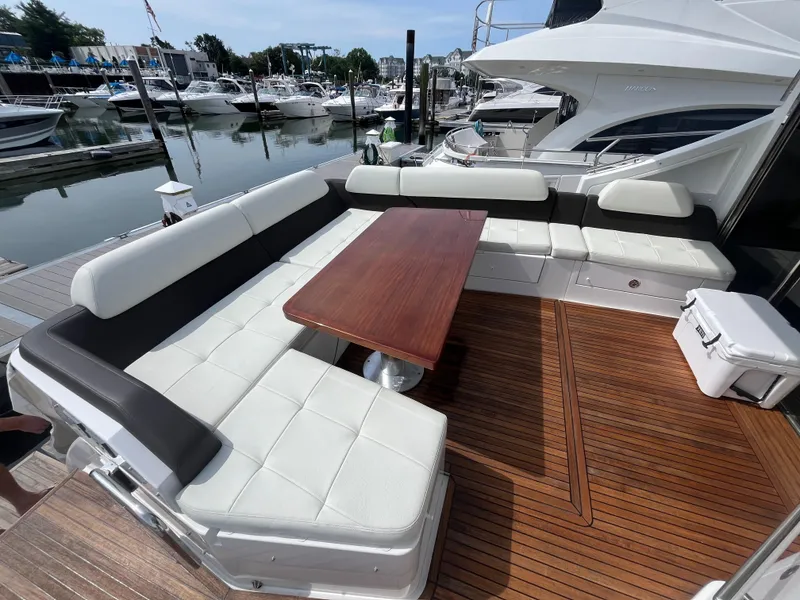 Slide: The Image of Luxury seating area on 2014 Azimut 55S yacht, featuring elegant wood table and marina view. - 8