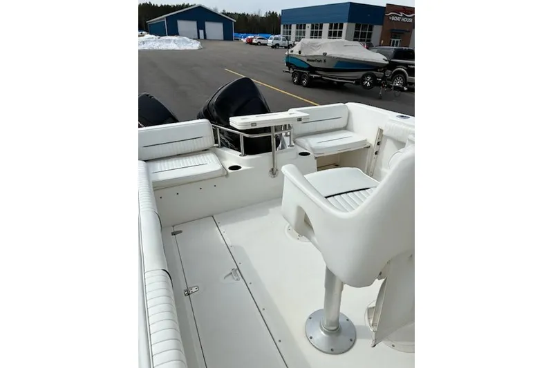 Slide: The Image of 1999 Boston Whaler 21 Outrage boat interior with seating and storage, parked near a showroom. - 8