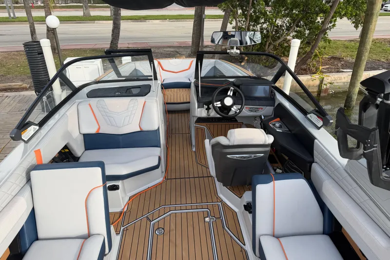 Slide: The Image of 2022 Nautique Super Air Nautique G25 interior with luxurious seating and teak flooring. - 10