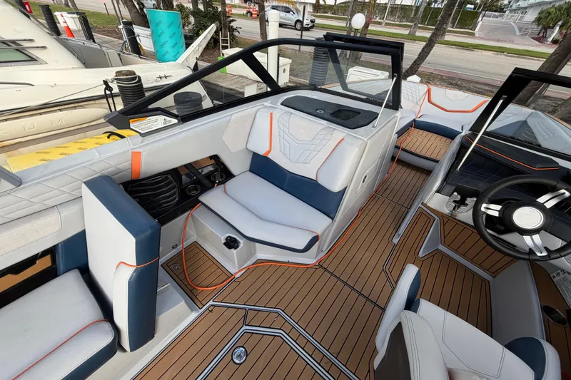 Slide: The Image of 2022 Nautique Super Air Nautique G25 boat interior with seating and steering wheel. - 18
