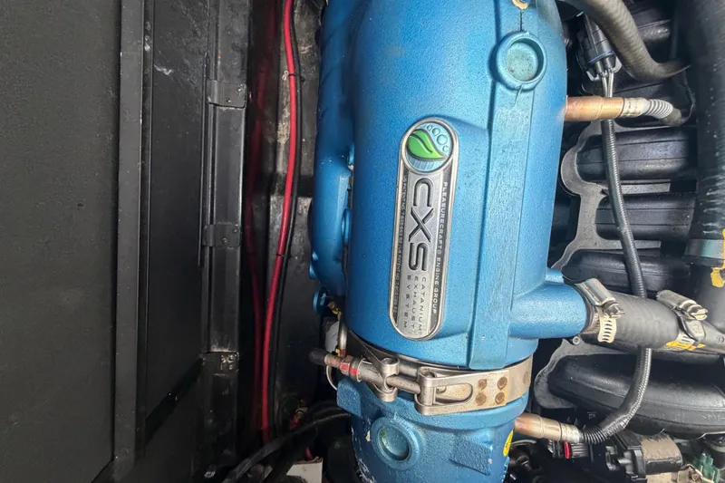 Slide: The Image of 2022 Nautique Super Air Nautique G25 engine compartment with storage, docked by water. - 21