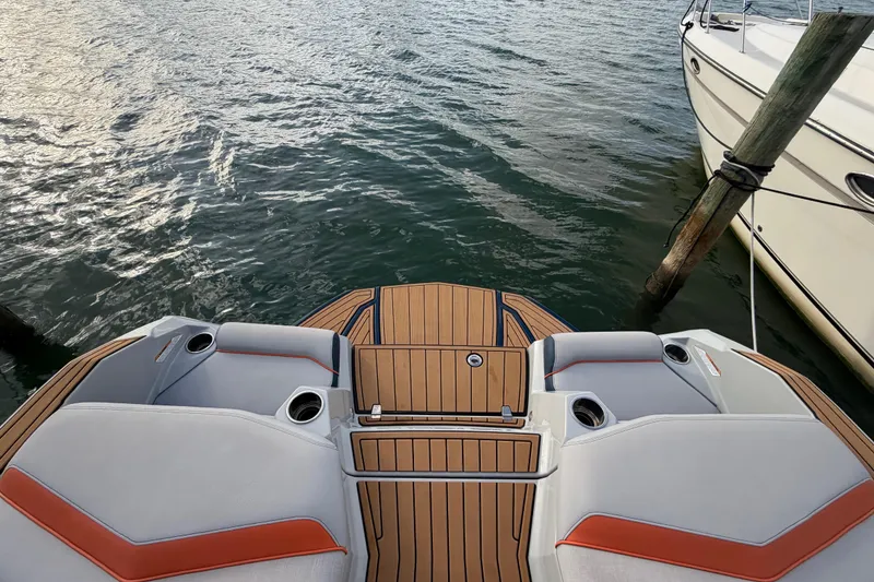 Slide: The Image of 2022 Nautique Super Air Nautique G25 boat docked on a lift by the water. - 4