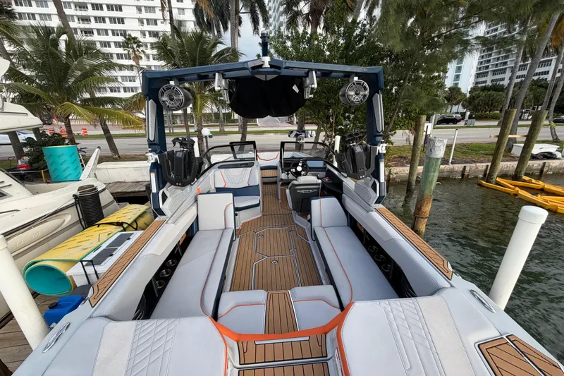 Slide: The Image of 2022 Nautique Super Air Nautique G25 boat docked on calm water. - 6