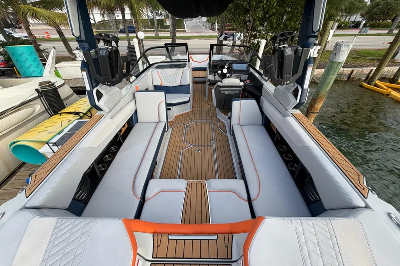 Slide: The Image of 2022 Nautique Super Air Nautique G25 boat interior with stylish seating and wood accents. - 8