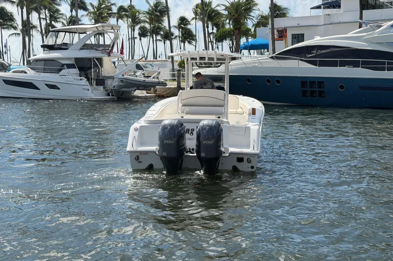Slide: The Image of 2022 Sea Hunt Ultra 275 SE boat on water, surrounded by yachts and palm trees. - 12