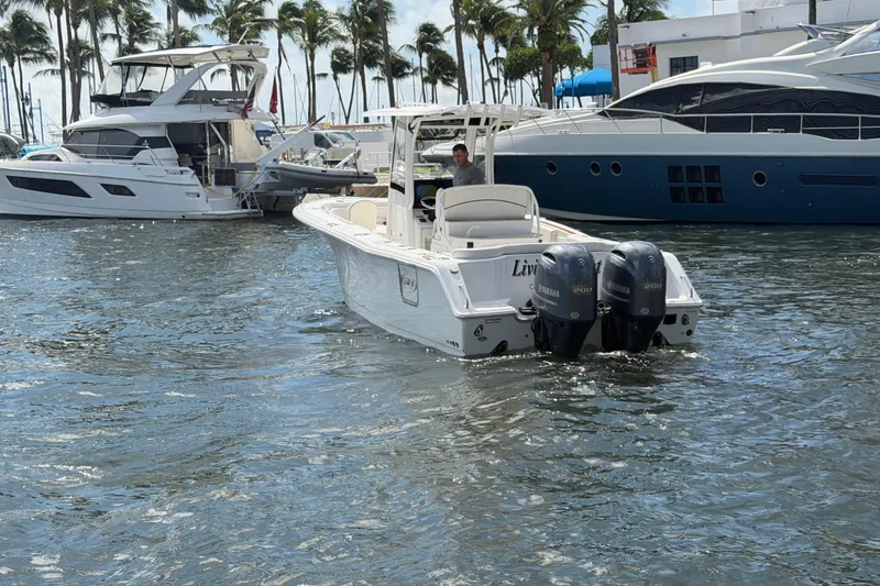 Slide: The Image of 2022 Sea Hunt Ultra 275 SE boat with twin Yamaha engines in a marina setting. - 13