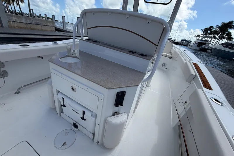 Slide: The Image of 2022 Sea Hunt Ultra 275 SE boat interior with sink and storage, docked by the marina. - 21