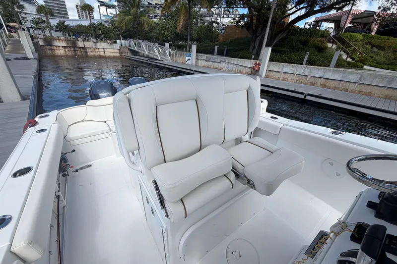 Slide: The Image of 2022 Sea Hunt Ultra 275 SE boat interior with white seating at dock. - 25