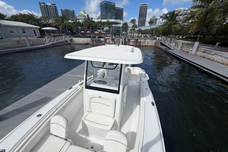 Slide: The Image of 2022 Sea Hunt Ultra 275 SE boat docked at a marina with modern buildings. - 32