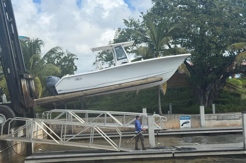 Slide: The Image of 2022 Sea Hunt Ultra 275 SE boat lifted by forklift at marina dock. - 42