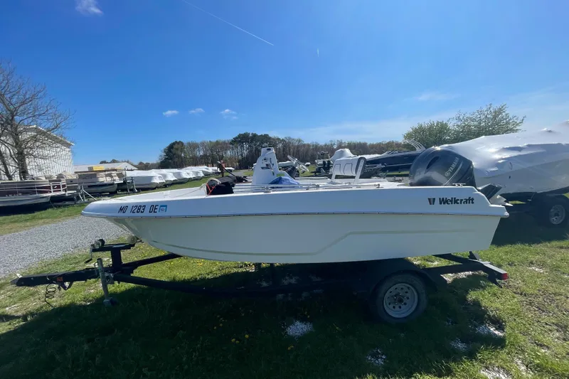 The Image of 2021 Wellcraft 162 Fisherman boat on trailer under clear blue sky. - 0