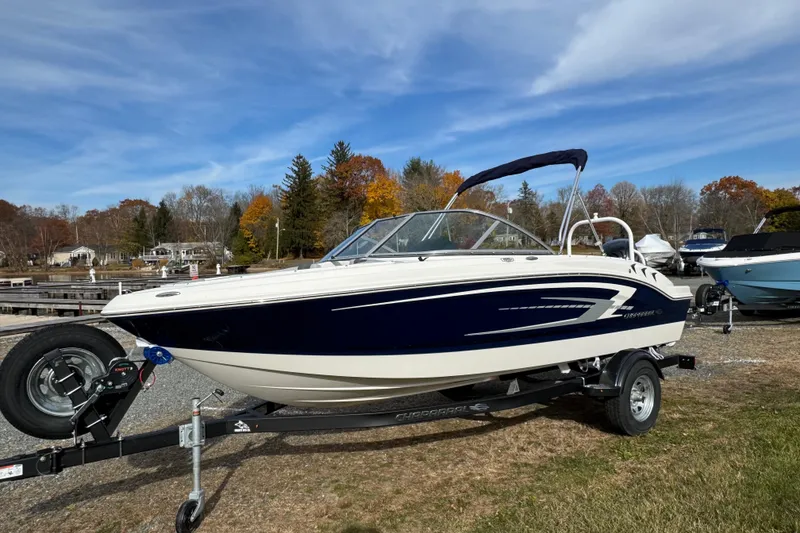 The Image of 2026 Chaparral 19 SSi OB boat on trailer, parked near a scenic lakeside. - 0