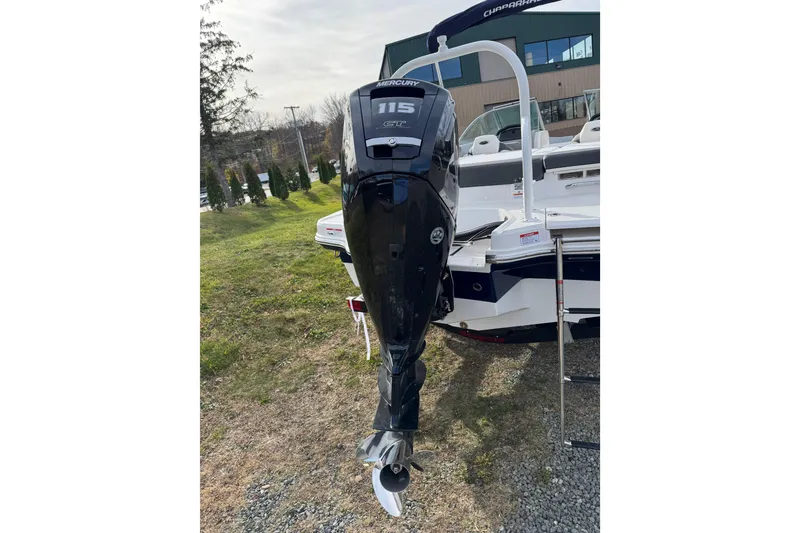 Slide: The Image of 2026 Chaparral 19 SSi OB boat with Mercury 115 outboard motor, parked on grass. - 16