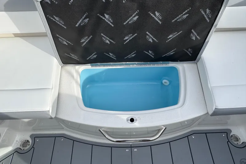 Slide: The Image of 2026 Chaparral 19 SSi OB boat storage compartment with open lid and blue interior. - 8