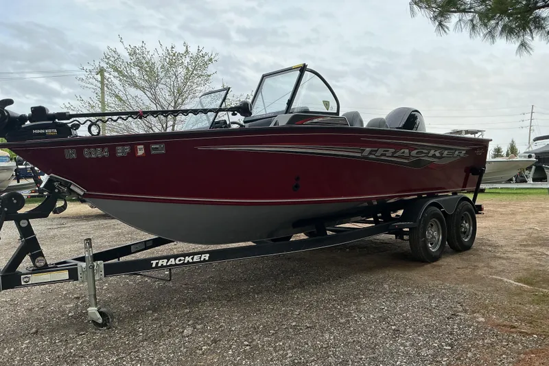 Slide: The Image of 2020 Tracker Targa V-18 WT boat on trailer, red exterior, parked outdoors. - 3