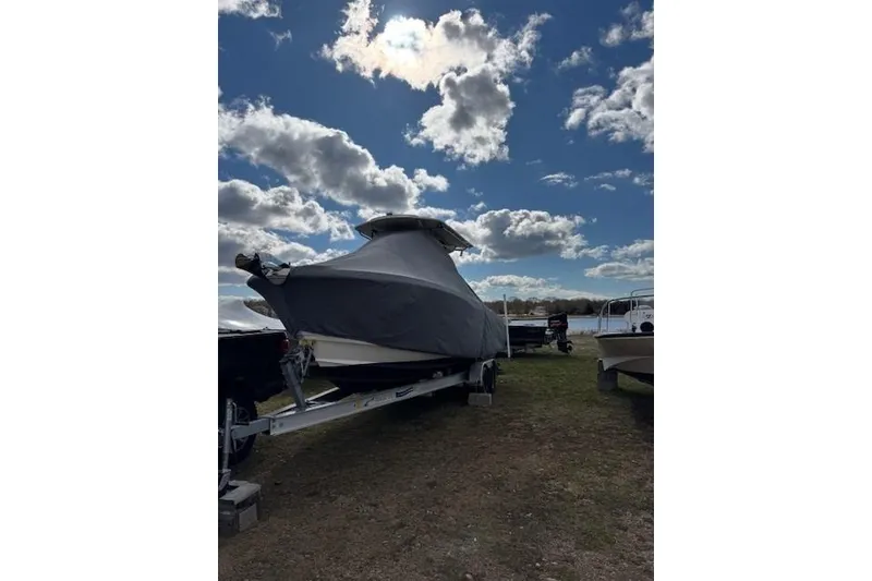 The Image of Covered 2015 Edgewater 245CC boat on trailer under cloudy sky. - 0
