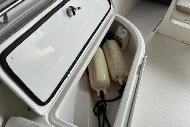 Slide: The Image of Storage compartment on 2015 Edgewater 245CC boat with fenders and cleaning supplies. - 10