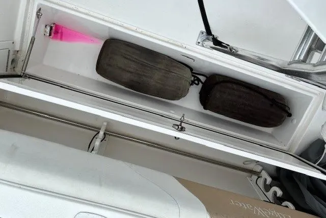 Slide: The Image of Storage compartment of a 2015 Edgewater 245CC boat with fenders and a pink buoy. - 12