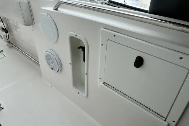 Slide: The Image of Interior view of a 2015 Edgewater 245CC boat, featuring storage compartments and speakers. - 13