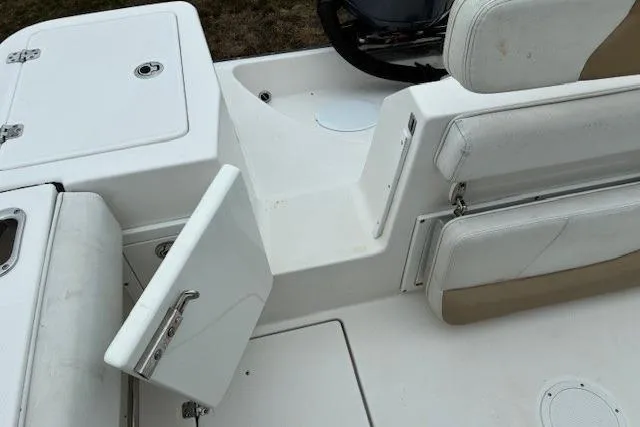 Slide: The Image of 2015 Edgewater 245CC boat interior with open storage compartment and seating. - 19