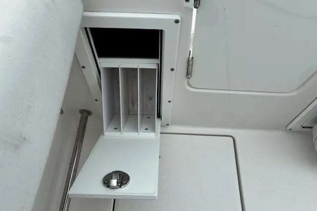 Slide: The Image of Storage compartment on a 2015 Edgewater 245CC boat, featuring organized slots. - 21