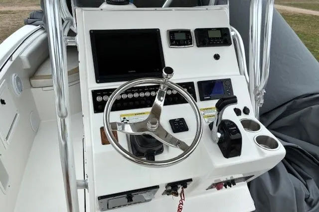 Slide: The Image of Control console of a 2015 Edgewater 245CC boat with steering wheel and navigation instruments. - 24