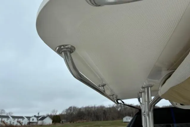 Slide: The Image of Edgewater 245CC 2015 boat canopy with stainless steel supports, outdoor setting. - 7