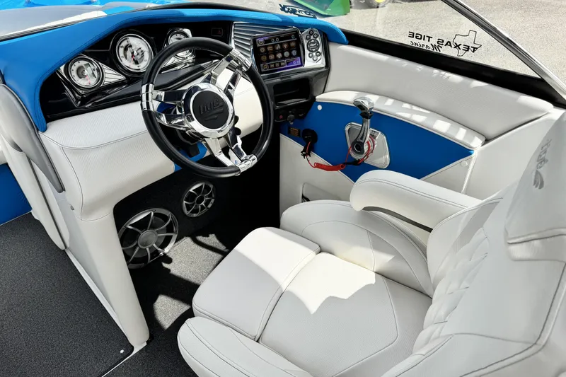 Slide: The Image of Interior of a 2013 Tigé RZ4 boat featuring a sleek steering wheel and modern dashboard. - 11