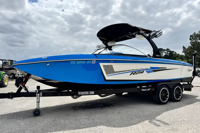 Slide: The Image of 2013 Tigé RZ4 boat in blue and white on a trailer under cloudy skies. - 7