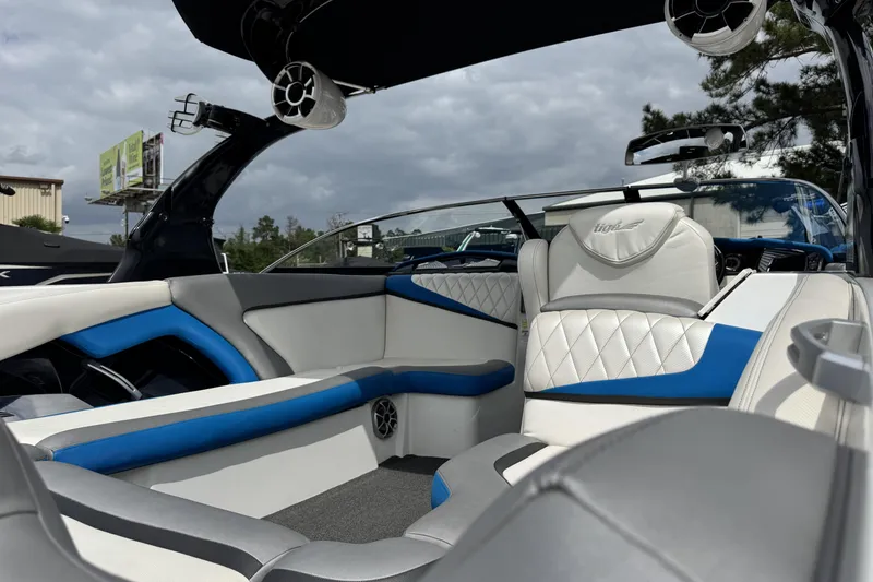 Slide: The Image of Interior of 2013 Tigé RZ4 boat with white and blue seating, under cloudy sky. - 9