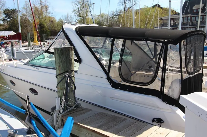 Slide: The Image of 2008 Maxum 2900 SE boat docked with black canopy and clear windows. - 2