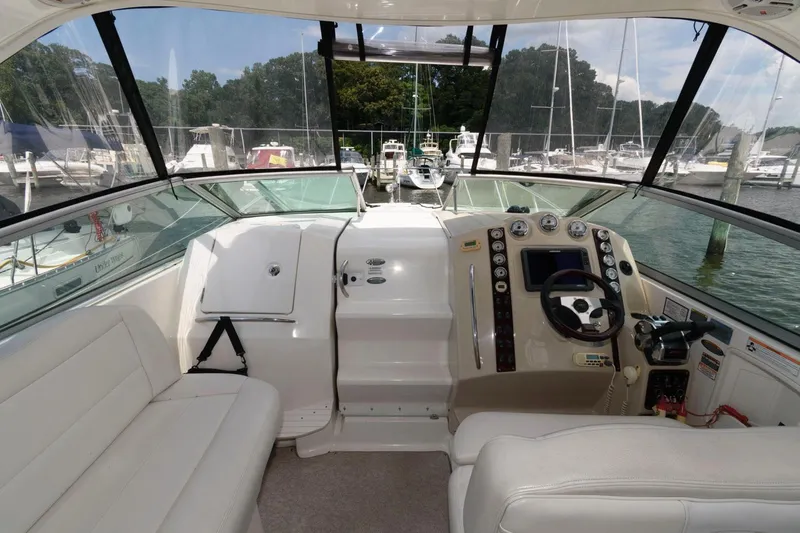 Slide: The Image of 2008 Maxum 2900 SE boat interior with helm, seating, and marina view. - 21