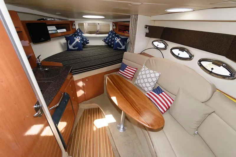 Slide: The Image of 2008 Maxum 2900 SE cabin interior with cozy seating, nautical decor, and wooden finishes. - 26